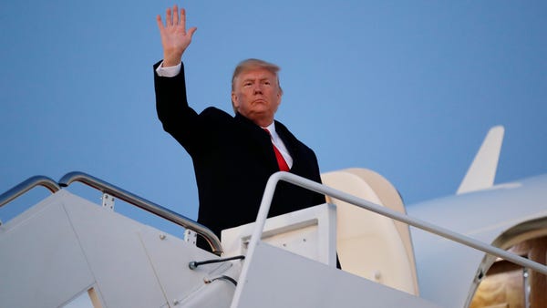 President Donald Trump waves while boarding Air Fo