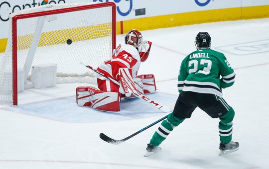 Dallas Stars defenseman Esa Lindell (23) watches as Detroit Red Wings goaltender Jonathan Bernier (45) gives up a goal to Stars forward Roope Hintz during the first period of an NHL hockey game.