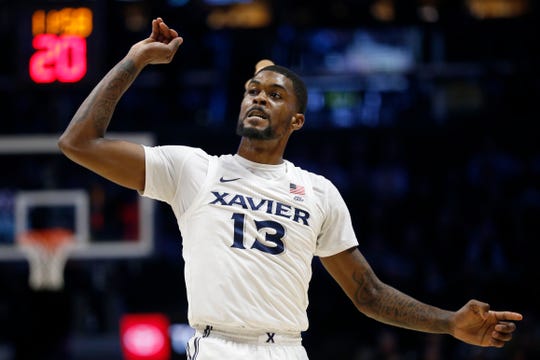 Xavier Musketeers forward Naji Marshall (13) follows through as he sinks a three point shot in the first half of the NCAA Big East game between the Xavier Musketeers and the St. John's Red Storm at the Cintas Center in Cincinnati on Sunday, Jan. 5, 2020. Xavier led 34-32 at halftime. 