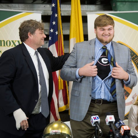 Cade Mays shows a Georgia T-shirt as he stands bet