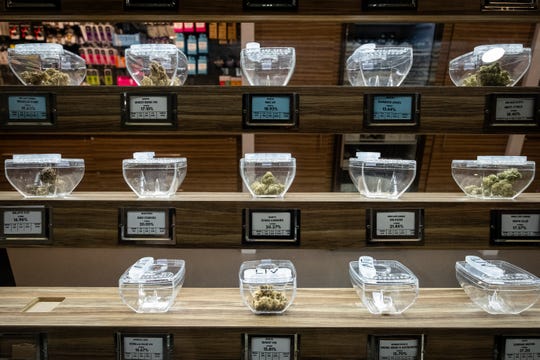 Different types of medical marijuana are arranged in containers on a shelf at LIV Ferndale.