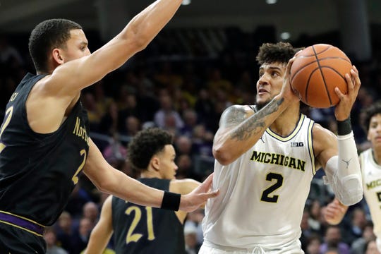 Michigan forward Isaiah Livers, right, looks to the basket against Northwestern forward Pete Nance.