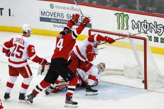 New Jersey Devils left wing Miles Wood (44) celebrates as a shot by Andy Greene (not shown) goes into the net behind Detroit Red Wings goaltender Jonathan Bernier on Thursday night.