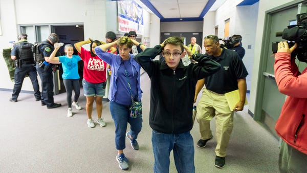 Students are led out of school as members of the F