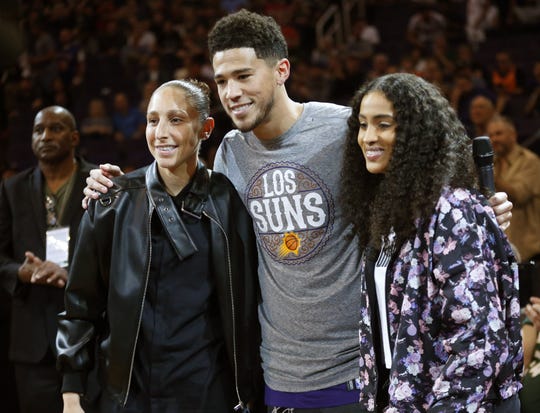 Phoenix Mercury guard Diana Taurasi and forward Skylar Diggins-Smith uses with Phoenix Suns guard Devin Booker before an NBA game between the Phoenix Suns and the Milwaukee Bucks in Phoenix March 8, 2020.