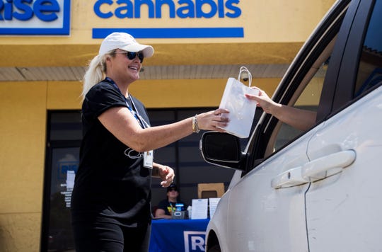 Ashley Alto, a shift supervisor for Rise Cannabis in Bonita Springs delivers product to a customer on Wednesday March 25, 2020. The  company is staying open amid the coronavirus pandemic. They are offering "herb-side pickup" to customers