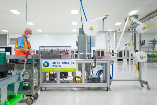 Aaron Leitz sets up and tests a machine that will be used to manufacture Level 1 face masks on Sunday at the General Motors Warren manufacturing facility. Production will begin next week and within two weeks ramp up to 50,000 masks per day, with the potential to increase to 100,000 per day. (Photo by John F. Martin for General Motors)