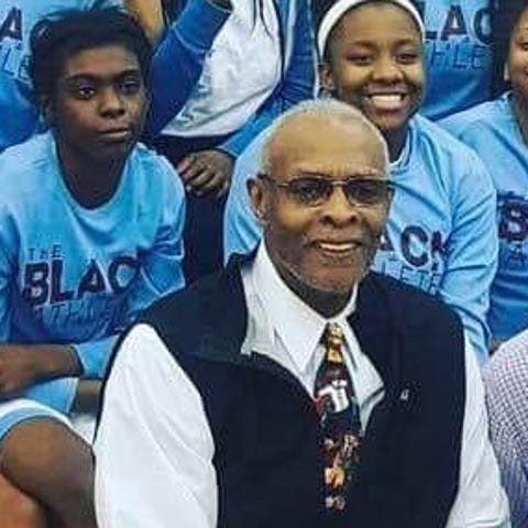 Dwight Jones poses with the Mumford High School gi