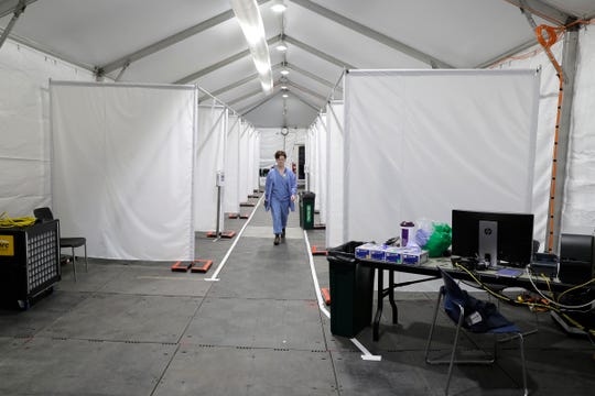 Forest Gauthier, an emergency services medical assistant, walks through a tent set up outside the Emergency Department at the Harborview Medical Center before it opened for patients, Thursday, April 2, 2020, in Seattle. The tent, which was recently put in place, is used to examine walk-up and other patients who arrive at the emergency room with respiratory symptoms possibly related to the new coronavirus. (AP Photo/Ted S. Warren) (Photo: Ted S. Warren, AP) 