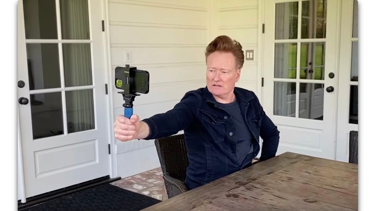 Conan O'Brien mugs with an iPhone