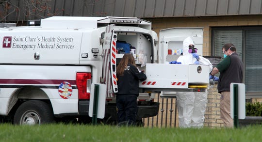 A paramedic dons a hazmat suit outside the Andover Rehabilitation and Subacute Care I and II in Andover Township Thursday, April 16, 2020. State officials said on Thursday that a total of 35 residents had died at the home, which is made up of two separate buildings, since the end of March, with 19 of of those deaths linked to COVID-19