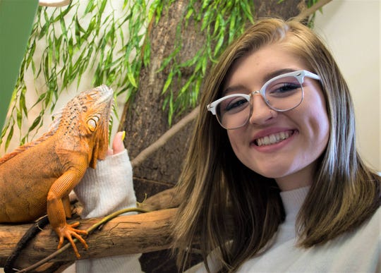 Kailey Cornell pets Frankie the red iguana at Wet Pets-N-Pals in Port Clinton. Kailey’s father, Dave Cornell, opened the shop, which sells fish and reptiles, in spring 2019.