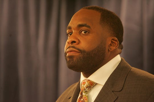 Detroit Mayor Kwame Kilpatrick listens to his lawyer Dan Webb speak to the media after Kilpatrick and his former chief of staff Christine Beatty were charged with multiple counts ofperjury, obstruction of justice, conspiracy and misconduct charges. KATHLEEN GALLIGAN/Detroit Free Press