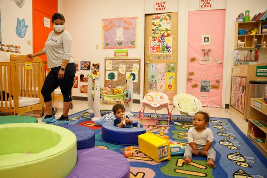 Valerie Velasquez, far left, watches over Izan Rosales and Legacy Wood as they play on the rug during daycare Tuesday, May 27, at the YWCA at the 1600 N. Brown location in El Paso.