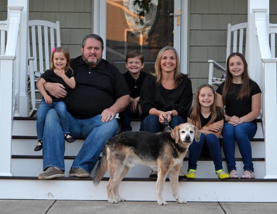 "At this point, you have to laugh about everything because it just keeps going and going," said Tara Paulson, shown with her family on the porch of their Ocean Township home. From left are Charlotte, Erik, Ryland, Tara, Kadence, Addison, and dog Jack.