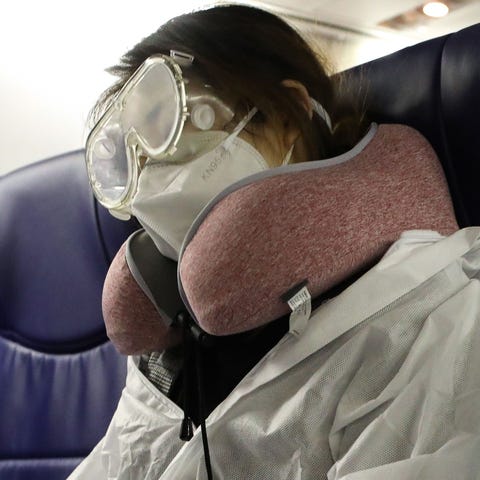 A passenger wears personal protective equipment on