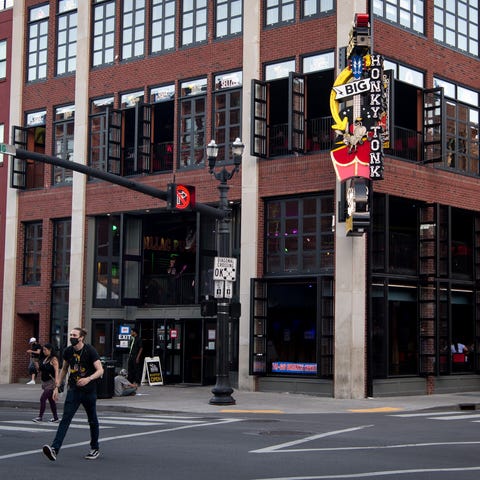 Pedestrians cross Broadway outside of Kid Rock's B