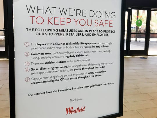 A sign regarding COVID-19 safety precautions and guidelines sits inside Westfield mall on Monday, June 22, 2020 in Palm Desert, Calif.