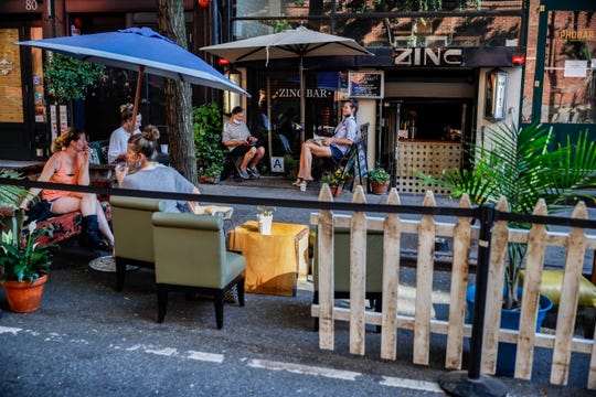 Customers dine outside PhoBar, Monday, June 22, 2020, in New York. New York City Mayor Bill de Blasio says he is delaying the planned resumption of indoor dining at restaurants in the city out of fear it would ignite a a spike in coronavirus infections.