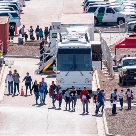 Migrants board buses to take them to shelters afte