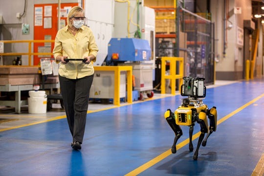 Paula Wiebelhaus navigates Fluffy the robot dog through the Van Dyke Transmission Plant. Ford is leasing two of the robots to map out its factories.