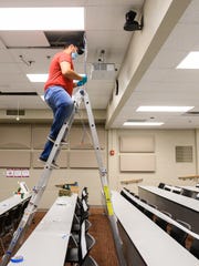 Luis Tovar, of New Mexico State University’s Information and Communications Technologies, sets up a hybrid classroom on the Las Cruces campus.