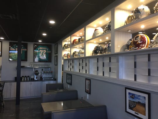 A wall of autographed NFL helmets divides the sports bar and sushi restaurant sides of Hatorando Sushi and Sports Bar in Hartland Township, Friday, Aug. 21, 2020.