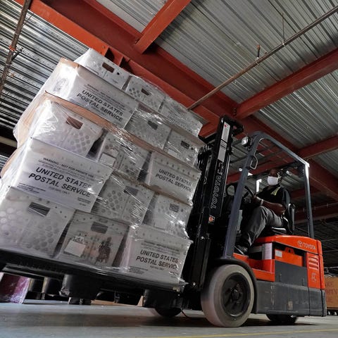 A forklift operator loads absentee ballots for mai