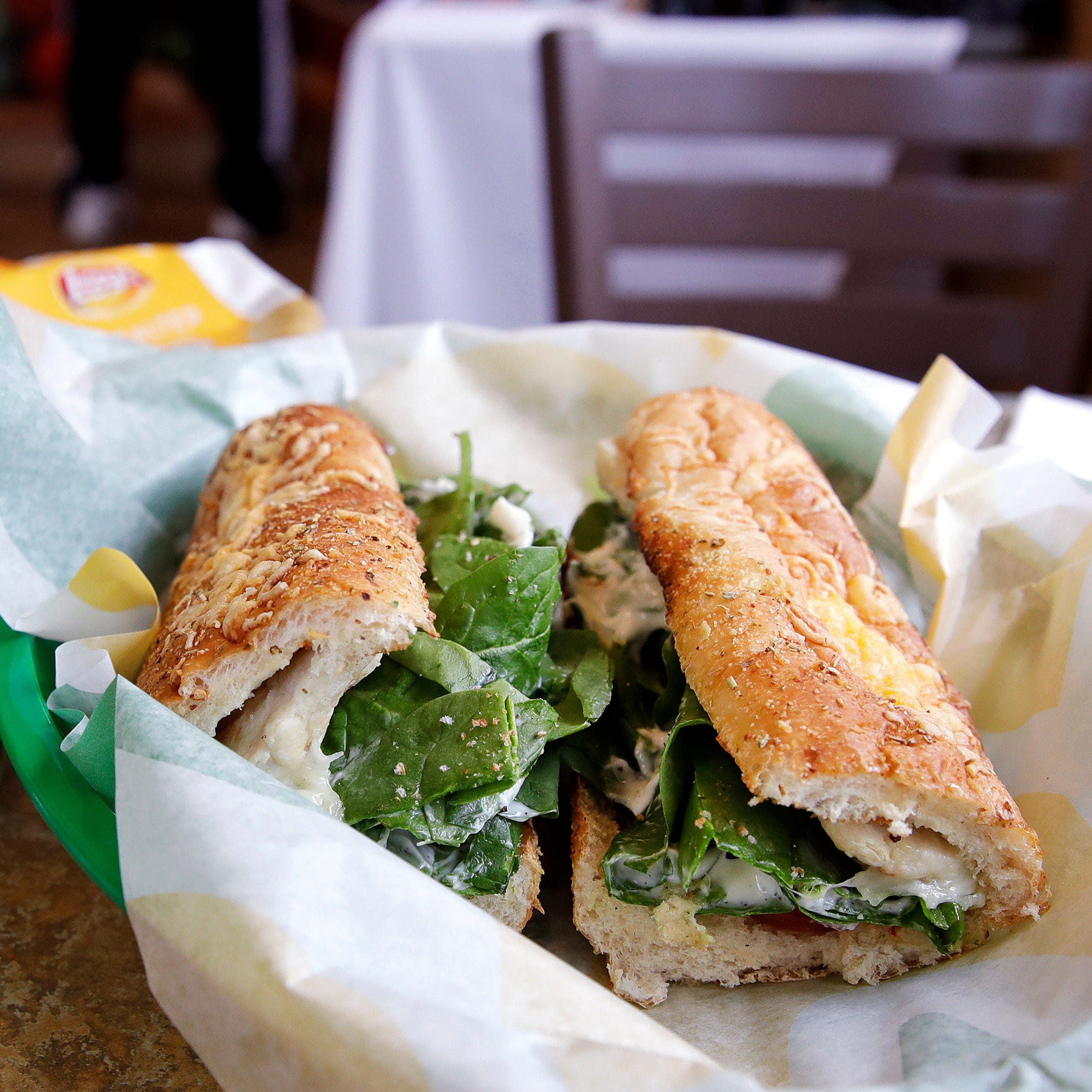 In this Friday, Feb. 23, 2018 file photo, the Subway logo is seen on a soft drink cup next to a sandwich at a restaurant in Londonderry, N.H.