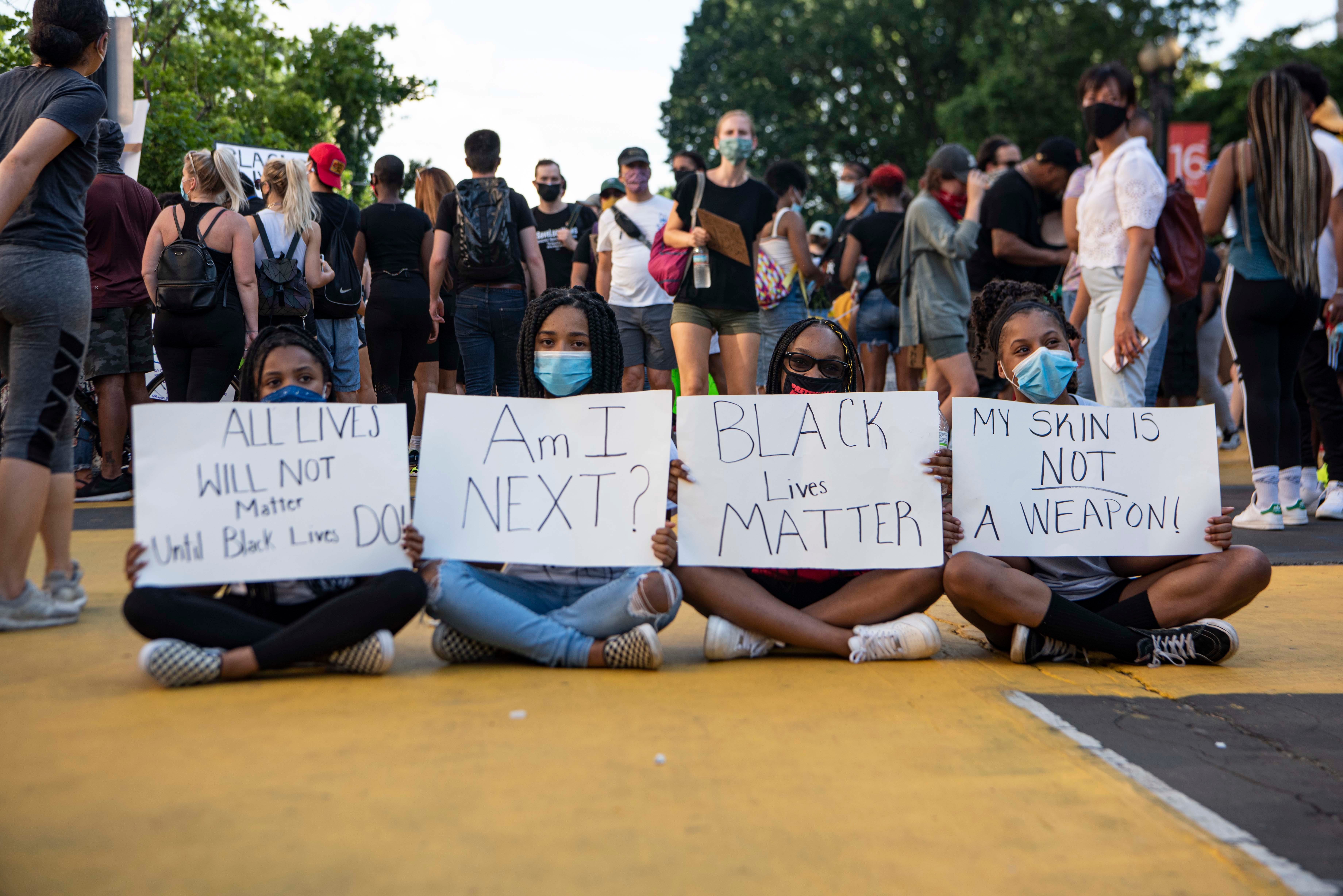 From left to right, Amari Hawkins, 14, Riley Goins, 15, Kaleigha Kendrick, 14, and Tierra Gibson, 14, hold signs on the newly renamed "Black Lives Matter Plaza" on 16th and I streets in downtown Washington, D.C., on Saturday, June 6, 2020. Protests continued following the death of George Floyd.