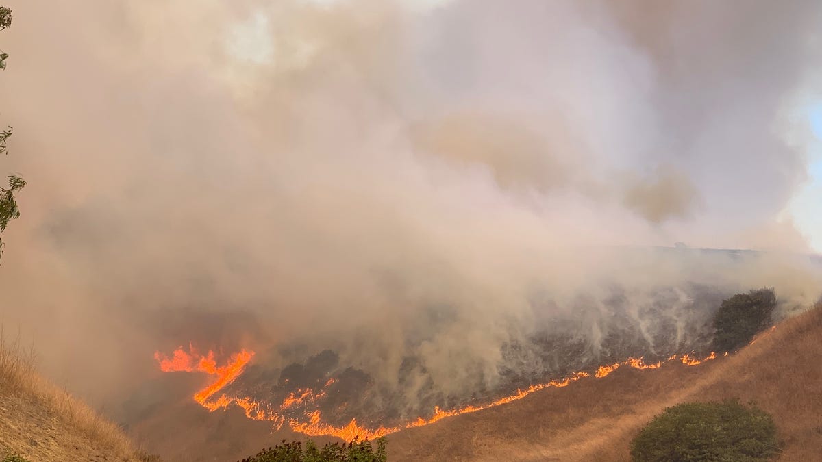 Flames from the Blue Ridge Fire can be seen on a ridge above Yorba Linda, Calif., on Oct. 26, 2020.