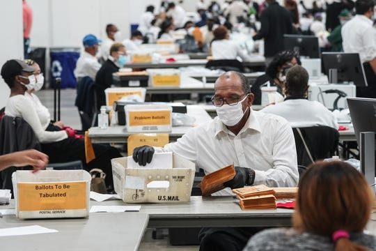 Poll workers count absentee ballots for the city of Detroit at the TCF Center in downtown Detroit on Tuesday, November 3, 2020.