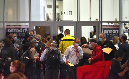 Ballot challengers and others stand outside the ballot-counting area after several windows were blocked, causing anger.