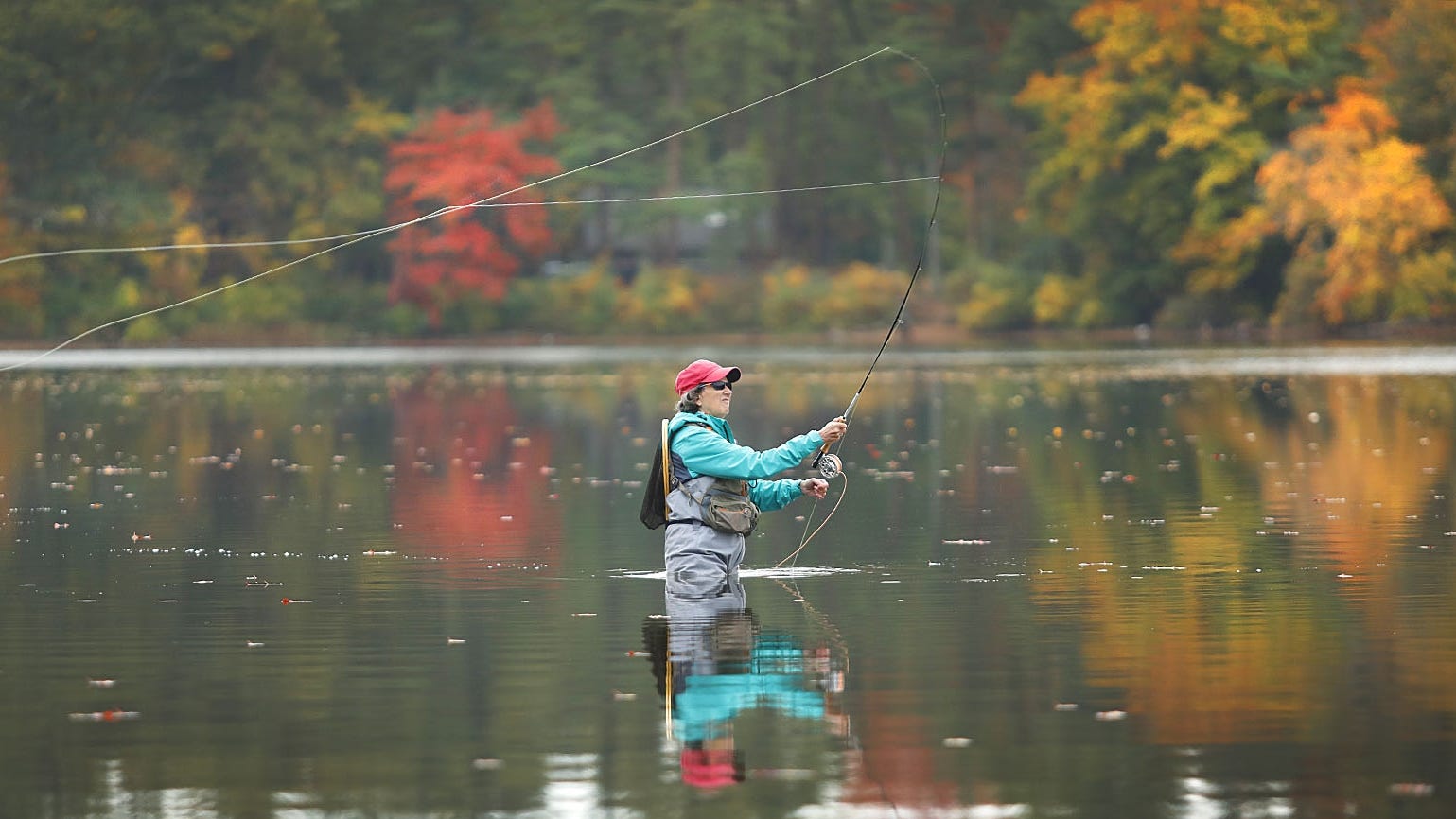 Cathy MacCurtain, of Braintree, who took up fly fishing three years ago, casts for trout in Houghton's Pond, Milton, on Tuesday, Oct. 20, 2020. (Greg Derr/ The Patriot Ledger)