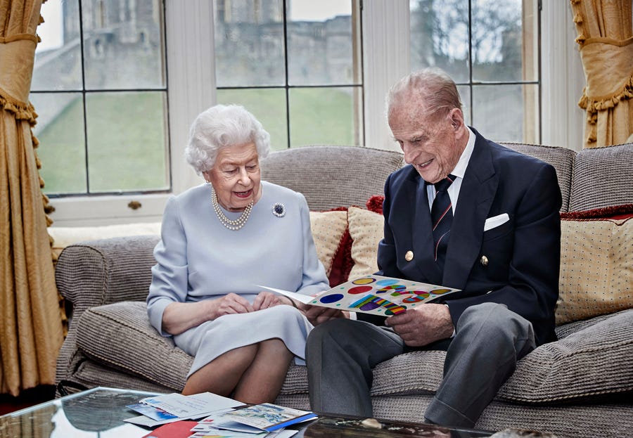 Queen Elizabeth II and Prince Philip, Duke of Edinburgh, look at homemade wedding anniversary card, given to them by their great grandchildren, at Windsor Castle ahead of their 73rd anniversary, Nov. 17, 2020.