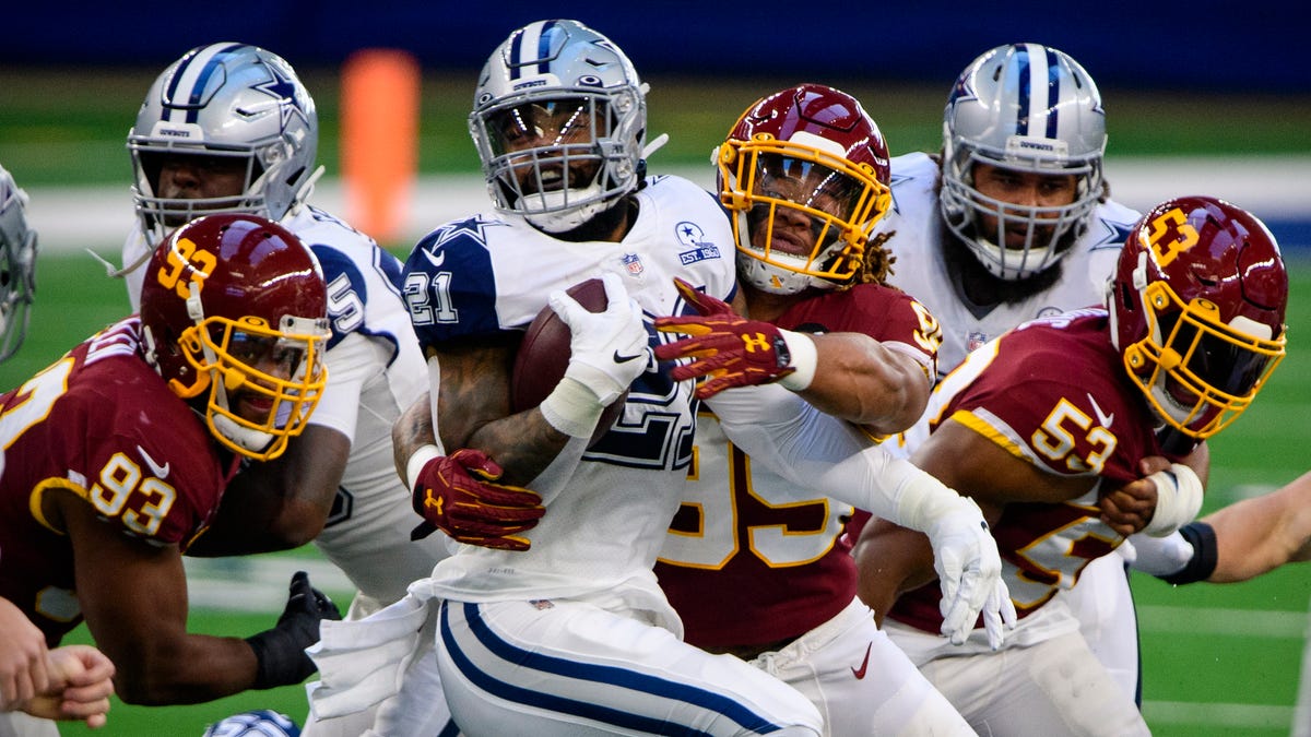 Dallas Cowboys running back Ezekiel Elliott is tackled by Washington Football Team defensive end Chase Young during Washington's 41-16 win on Thanksgiving Day.