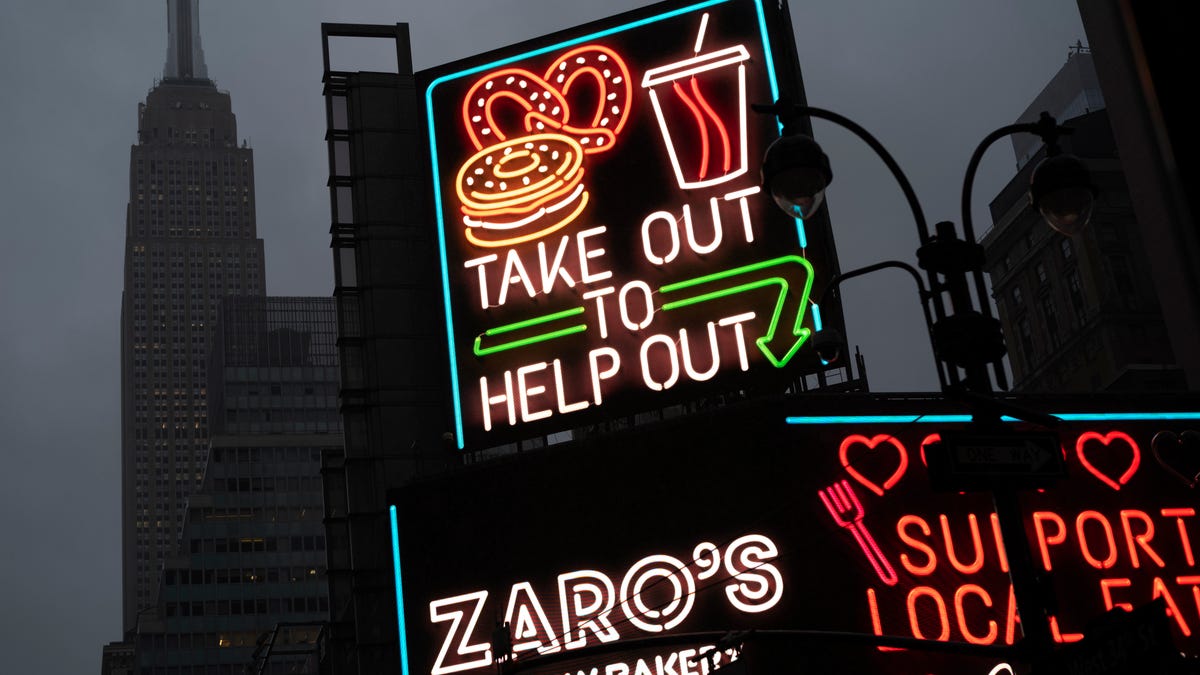 A billboard in midtown Manhattan reads "Take Out To Help Out, Monday, Nov. 30, 2020 in New York. (AP Photo/Mark Lennihan)