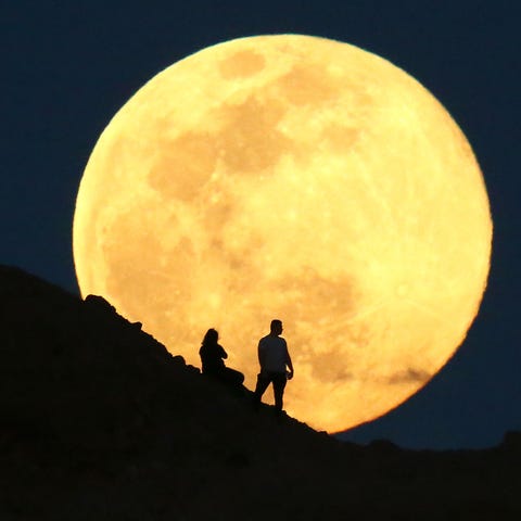 The supermoon, also known as the pink moon rises o