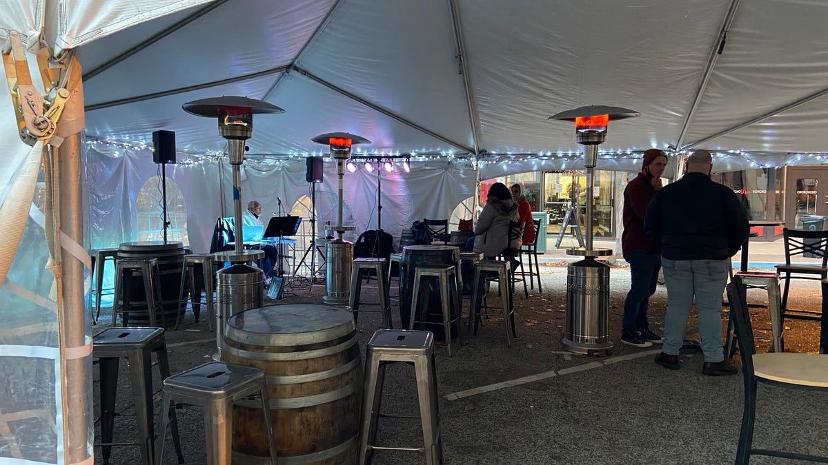 Patrons gather inside the heated tent that is shared by Buzz Bomb Brewing Company, Cafe Moxo and other businesses on Adams Street in downtown Springfield. A compromise was reached between the Springfield Fire Department and local businesses that will allow propane heaters to continue to be utilized inside the tents.