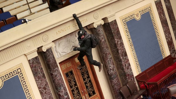 A protester is seen hanging from the balcony in th