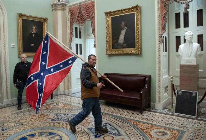 A Pro-Trump rioter carries a Confederate flag near the US Capitol Rotunda on Jan. 6, 2021, in Washington, DC.