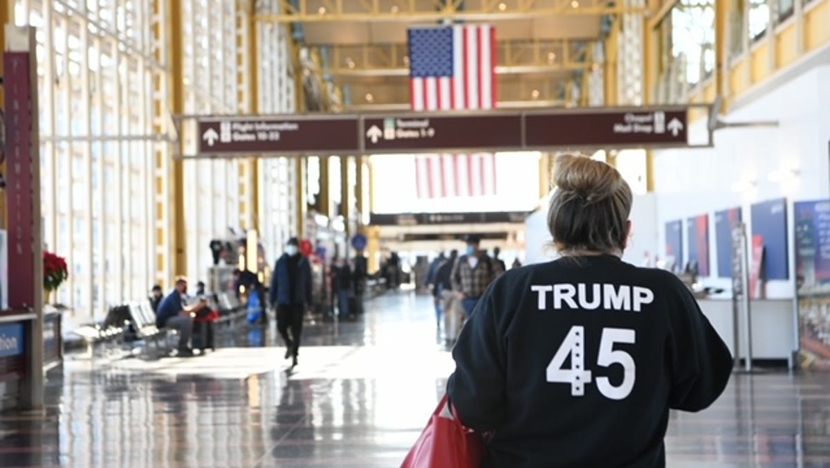 A Trump supporter walks in the B Terminal of Ronald Reagan Washington National Airport the day after massive pro-Trump crowds stormed the Capitol Building during a joint session of Congress to certify the 2020 presidential election results.