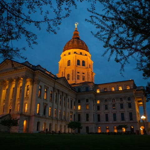 The Kansas Statehouse is lit as legislature contin