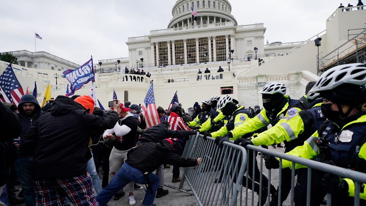 A pro-Trump mob tries to break through a police barrier, Wednesday, Jan. 6, 2021, at the Capitol in Washington. (AP Photo/Julio Cortez)