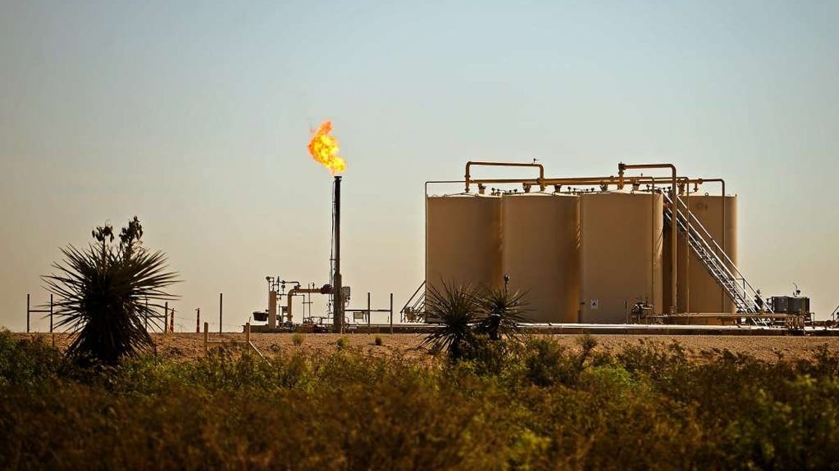 A natural gas flare burns near storage tanks in Reeves County in West Texas.