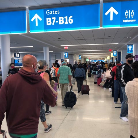 Travelers wear face masks at a busy American Airli