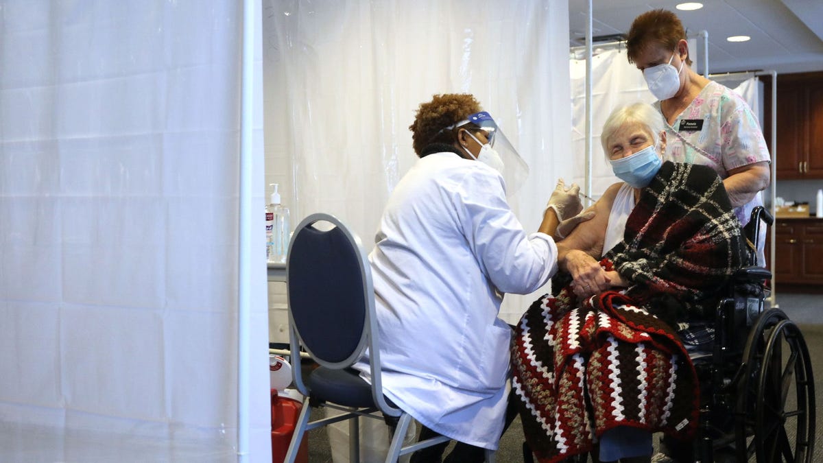 Betty Hermanek winces as she receives her COVID-19 vaccine at the Caledonia Senior Living and Memory Care in North Riverside, Tuesday, Jan. 12, 2021.