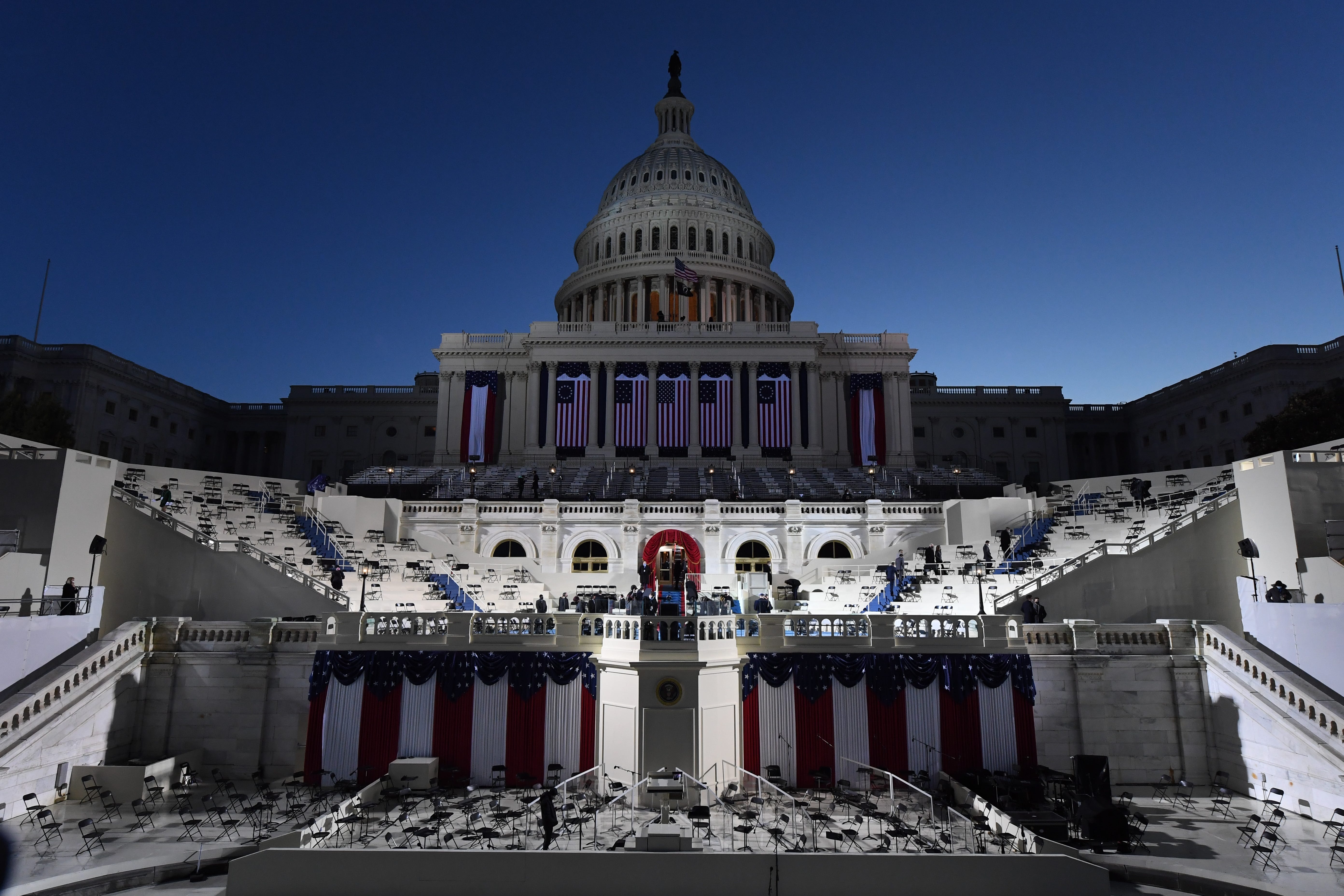 The West Front of the U.S. Capitol is illuminated as the sun begins to rise before the 2021 Presidential Inauguration.