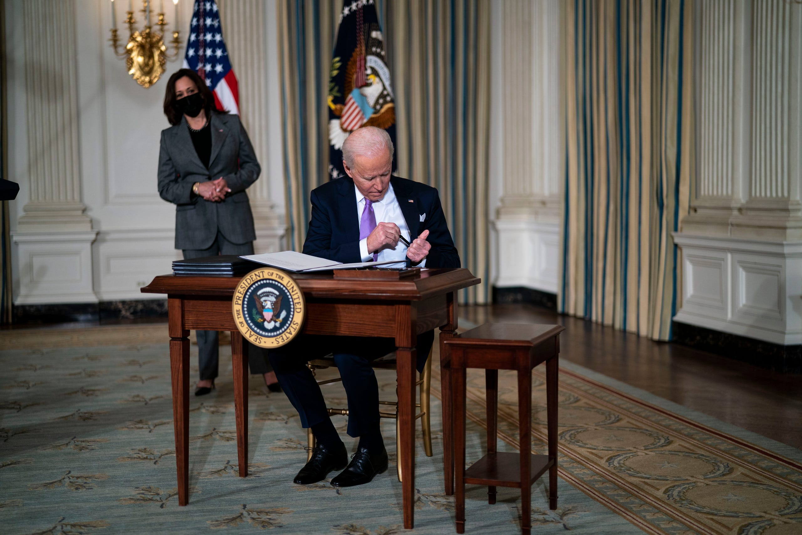 Vice President Kamala Harris looks on as President Joe Biden signs executives orders related to his racial equity agenda on Jan. 26, 2021.