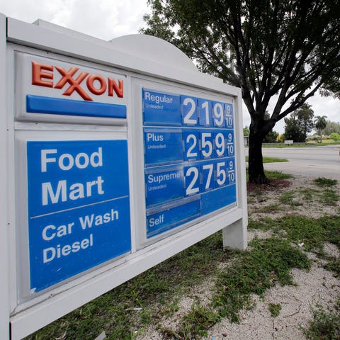 A motorist drives by an Exxon sign displaying gas 